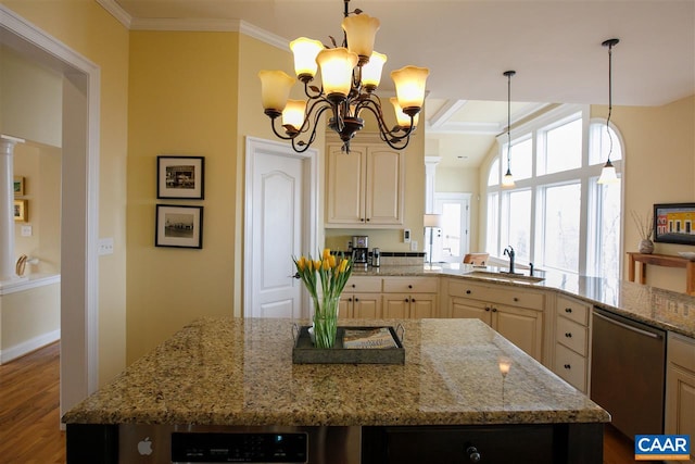 kitchen featuring light stone counters, a center island, ornamental molding, a sink, and dishwasher