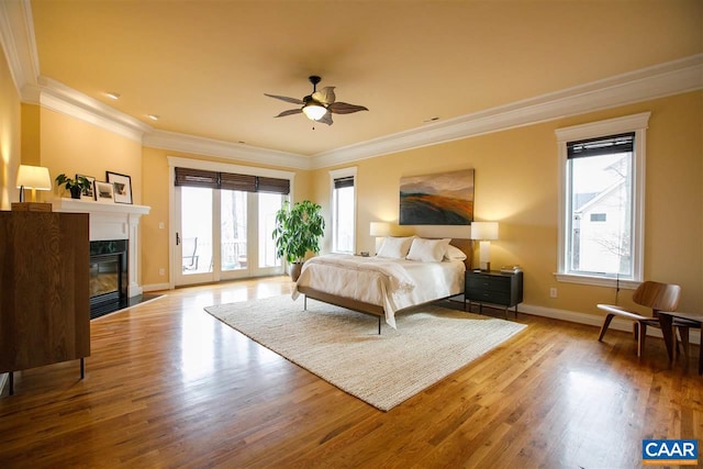 bedroom with access to exterior, multiple windows, and wood finished floors