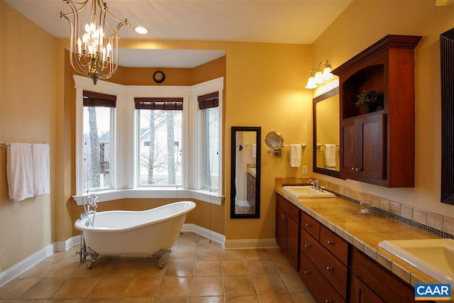 full bathroom featuring a soaking tub, a sink, baseboards, and double vanity