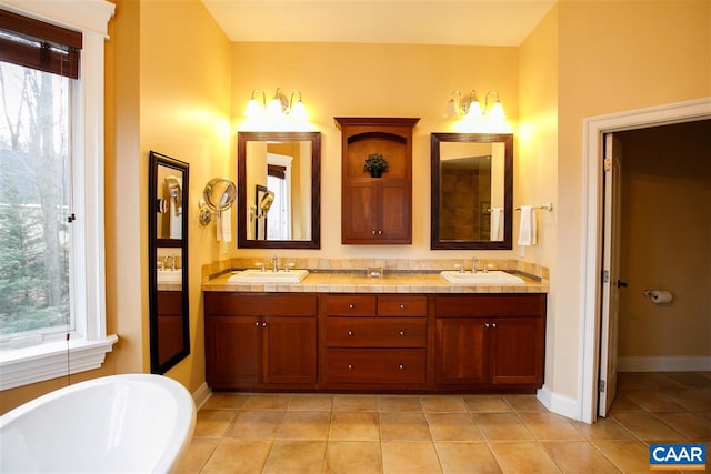 bathroom with tile patterned floors, a sink, and a healthy amount of sunlight