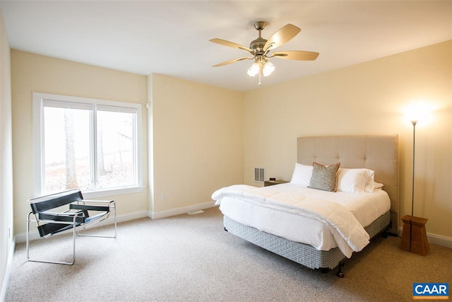 carpeted bedroom with a ceiling fan, visible vents, and baseboards