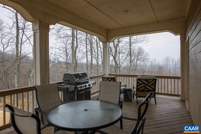 wooden terrace with area for grilling and outdoor dining space