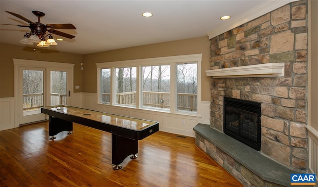 game room with wainscoting, a fireplace, wood finished floors, and visible vents