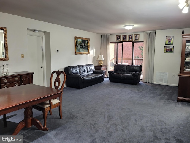 living area featuring visible vents and dark colored carpet