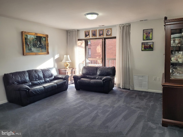 living room featuring dark colored carpet, visible vents, and baseboards