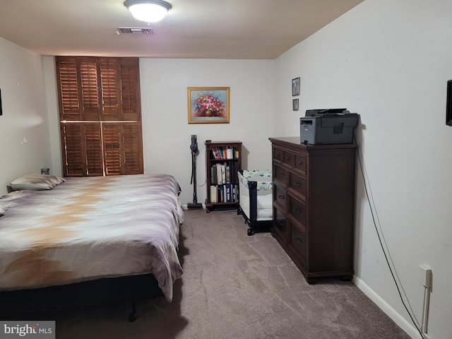 bedroom featuring baseboards, visible vents, and light carpet