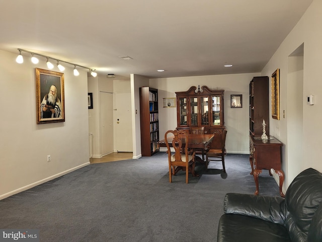 dining area with dark colored carpet and baseboards