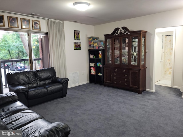 living area with baseboards, visible vents, and carpet floors