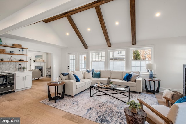 living room with high vaulted ceiling, sink, wine cooler, light hardwood / wood-style flooring, and beamed ceiling