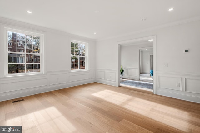 empty room with wood-type flooring and ornamental molding