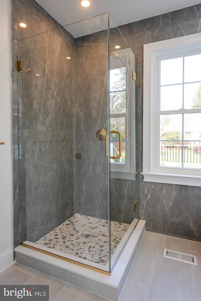 bathroom with tile patterned floors and a shower with door