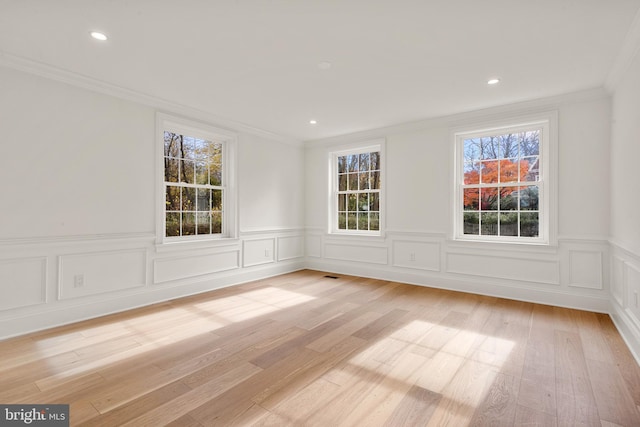 unfurnished room with crown molding and light wood-type flooring