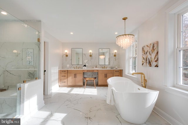 bathroom featuring a chandelier, vanity, and a bath