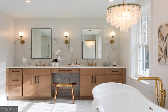 bathroom featuring vanity, an inviting chandelier, and a healthy amount of sunlight