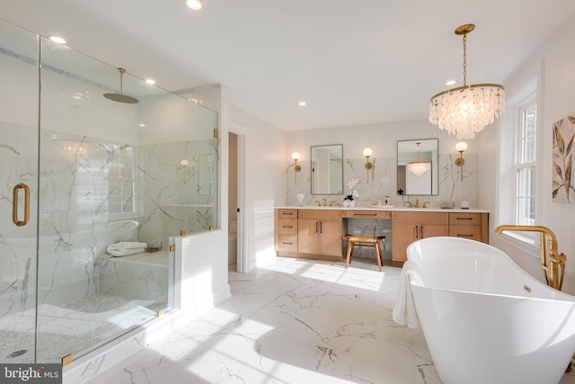 bathroom with a chandelier, shower with separate bathtub, and vanity