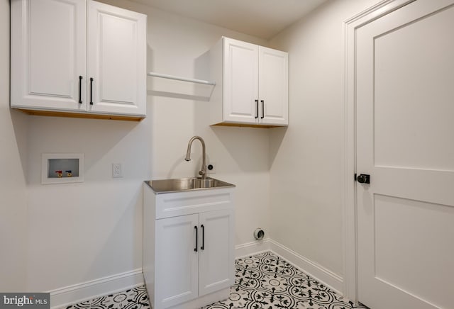 clothes washing area with cabinets, washer hookup, light tile patterned floors, and sink