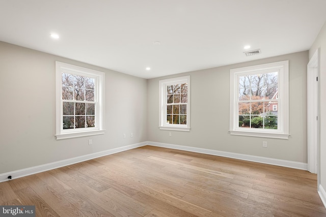 spare room featuring light hardwood / wood-style flooring and plenty of natural light