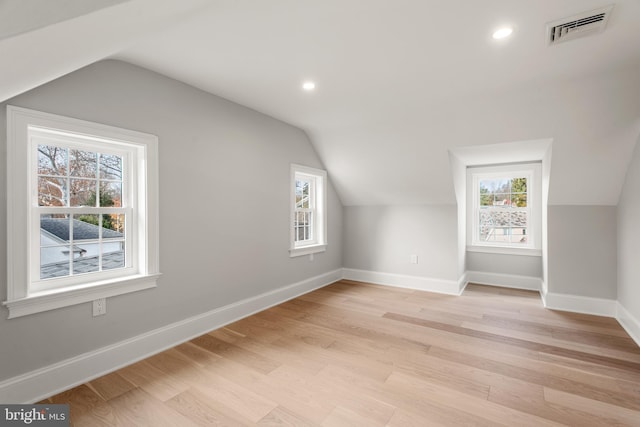 additional living space with light wood-type flooring and lofted ceiling