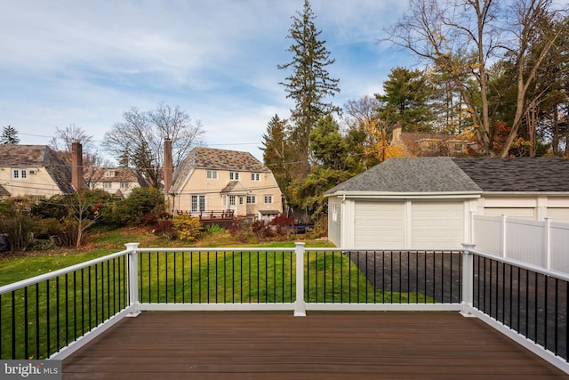 wooden deck with a lawn, a garage, and an outdoor structure