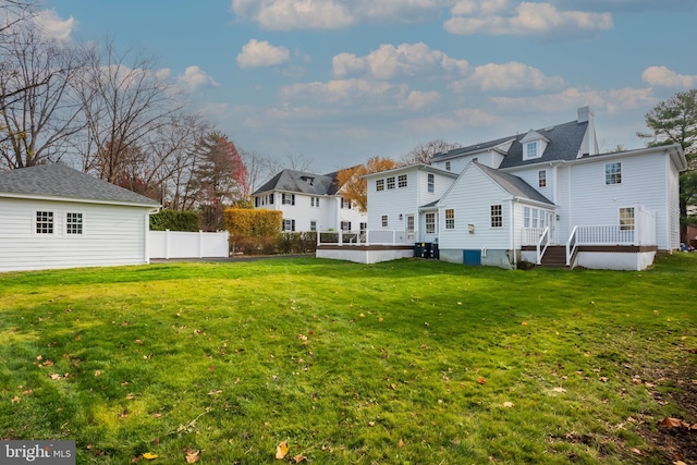 back of house featuring a deck and a yard