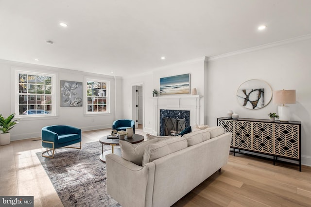 living room featuring light hardwood / wood-style floors, crown molding, and a premium fireplace