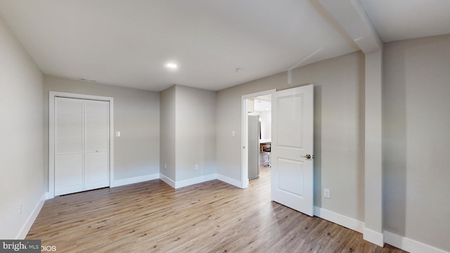 interior space with stainless steel fridge, light hardwood / wood-style flooring, and a closet