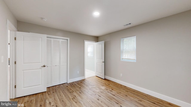 unfurnished bedroom with a closet and light hardwood / wood-style flooring