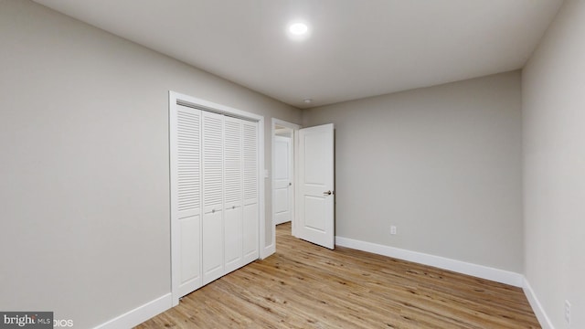 unfurnished bedroom with a closet and light hardwood / wood-style flooring