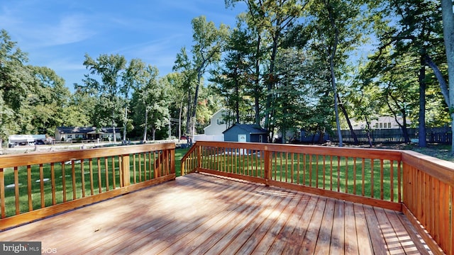 wooden terrace featuring a yard