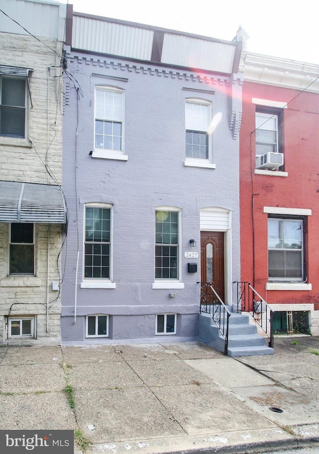 view of property with brick siding and cooling unit