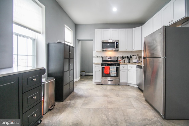 kitchen with backsplash, sink, stainless steel appliances, and white cabinets