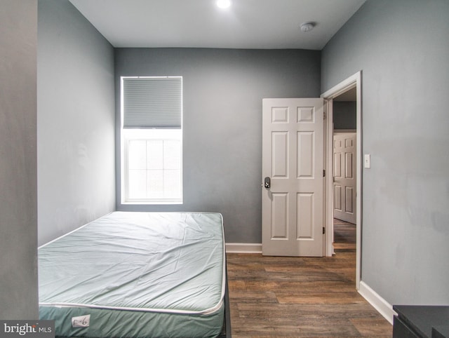 bedroom with dark hardwood / wood-style flooring