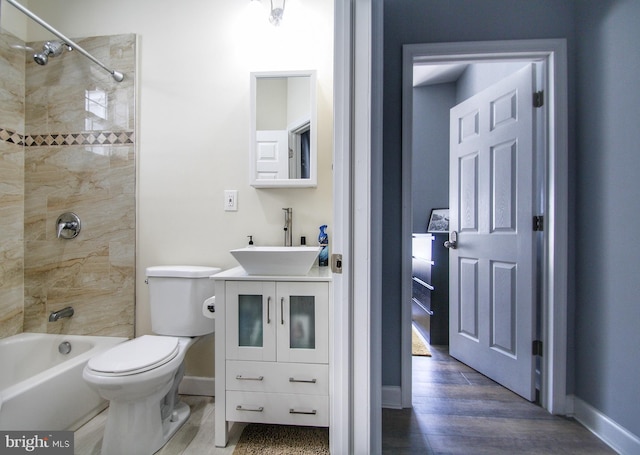 full bathroom featuring tiled shower / bath combo, toilet, vanity, and hardwood / wood-style floors