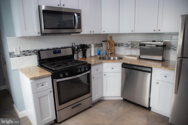 kitchen featuring white cabinets, appliances with stainless steel finishes, and sink