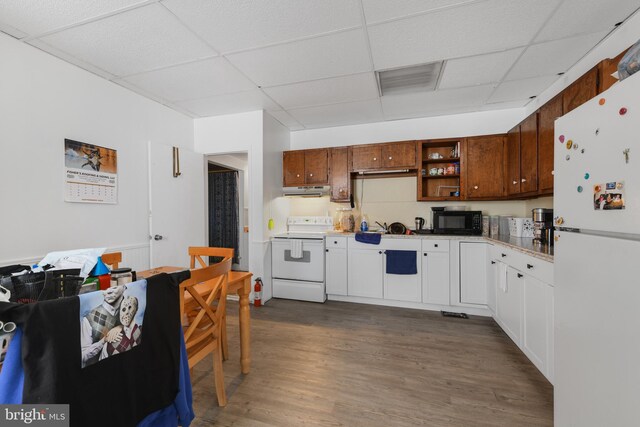 kitchen featuring a paneled ceiling, white appliances, dark hardwood / wood-style floors, and white cabinets