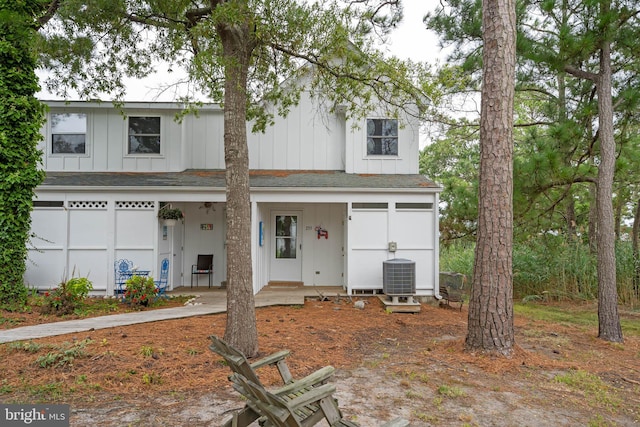 view of front of house featuring board and batten siding, roof with shingles, and central air condition unit