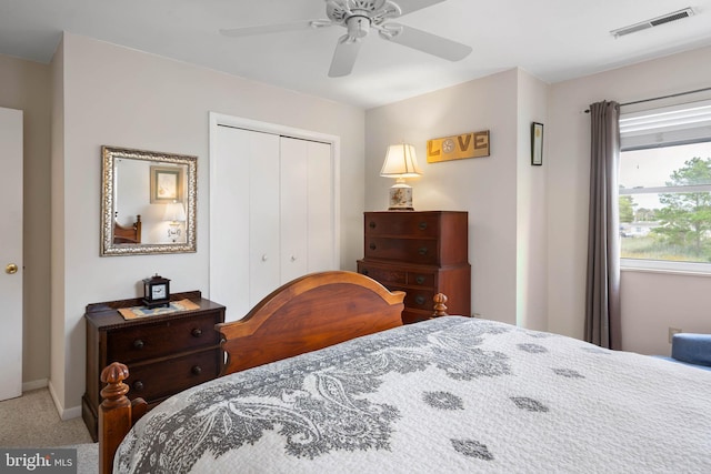 carpeted bedroom featuring baseboards, a closet, visible vents, and a ceiling fan