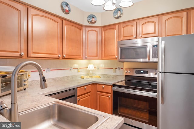 kitchen with an inviting chandelier, tasteful backsplash, stainless steel appliances, and sink