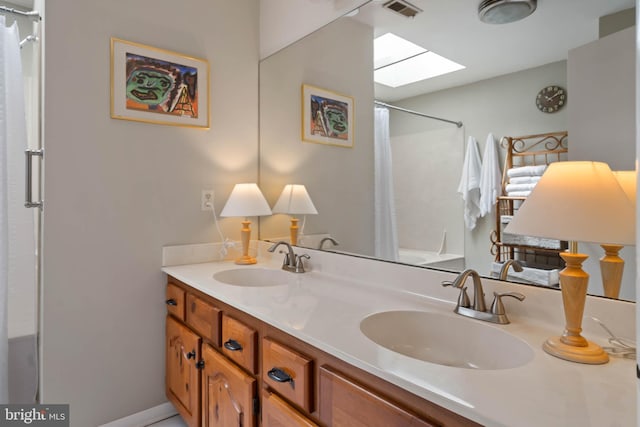 bathroom featuring a skylight, visible vents, a sink, and a shower with curtain