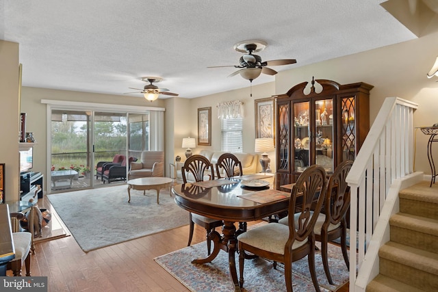 dining area featuring a textured ceiling, ceiling fan, and wood-type flooring