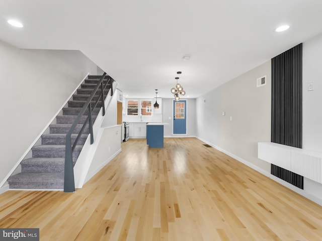 unfurnished living room with recessed lighting, visible vents, baseboards, stairs, and light wood-style floors