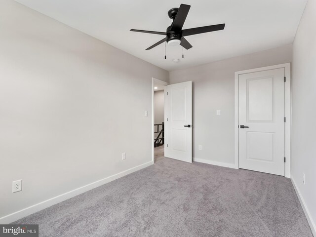 carpeted empty room featuring ceiling fan