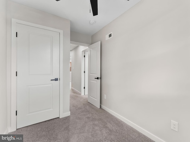 unfurnished bedroom with ceiling fan and light colored carpet