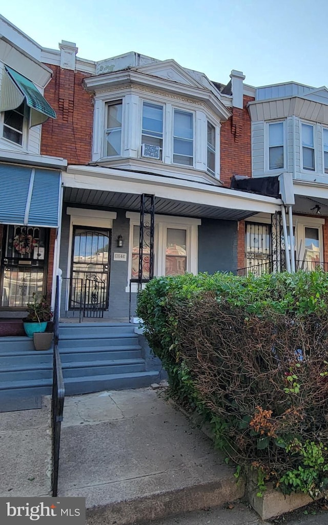 townhome / multi-family property featuring covered porch