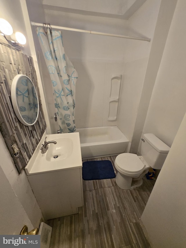 bathroom with toilet, vanity, shower / tub combo, and wood finished floors