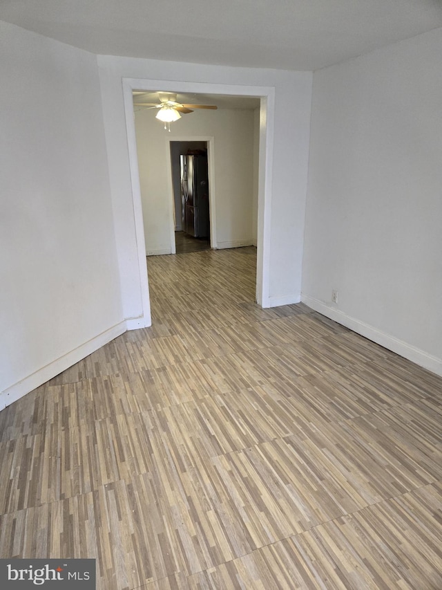 spare room with ceiling fan, baseboards, and wood finished floors