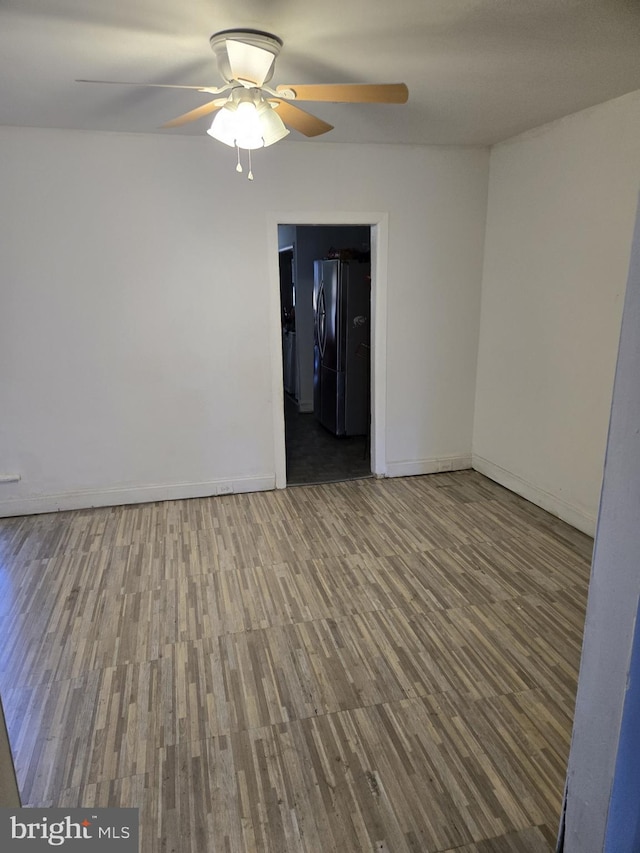 spare room with ceiling fan, baseboards, and wood finished floors