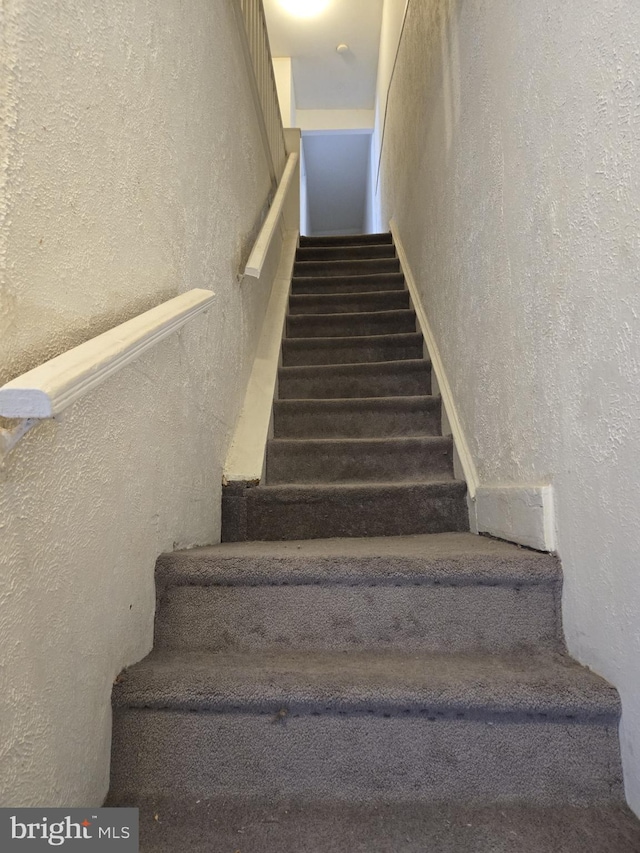 staircase with a textured wall