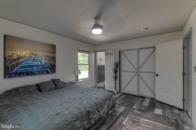 bedroom with ceiling fan, hardwood / wood-style floors, and a textured ceiling