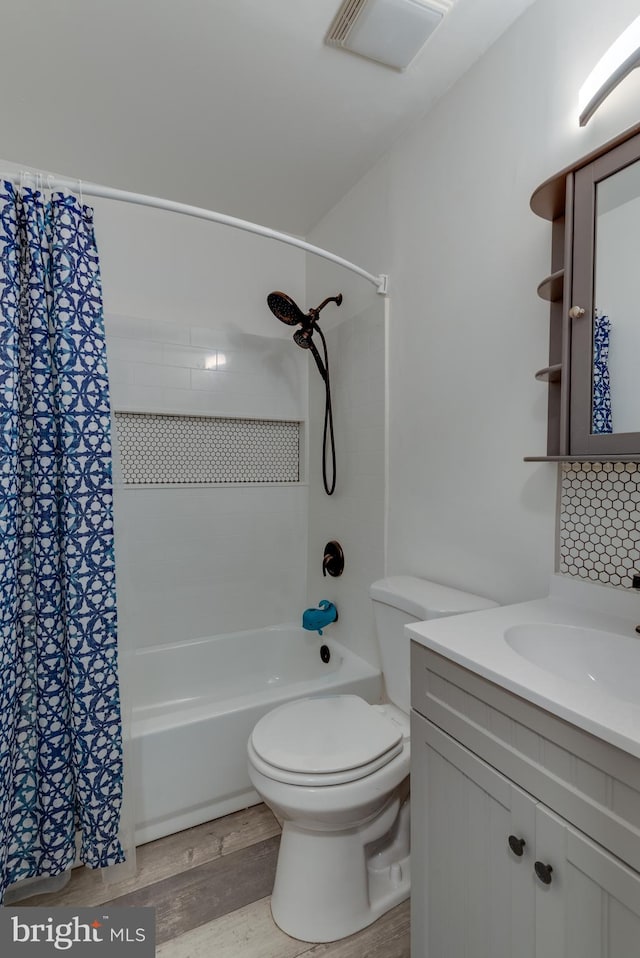 full bathroom with wood-type flooring, vanity, shower / tub combo, and toilet